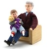 Popjes voor poppenhuis, een grootvader zit in een houten zetel, een klein jongetje met Teddy Bear on his lap.