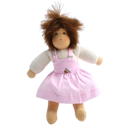 Klein popje van 25 cm, rechtstaand, met bruin mohair haar, bruine ogen, een witte t-shirt met lange mouwen, en roos overgooier jurk.
