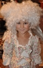 Detail of a smiling girl in a white princess dress with a print of bouquets of roses and 3 ribbons on the chest in the style of Madame de Pompadour. She is wearing a big wig.