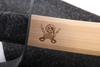 Détail du sabre de pirate en bois naturel avec impression de pirate brune sur le haut de la lame, protection en cuir et garnissage de la poignée en feutre de laine noire.