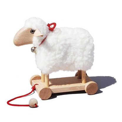 Houten schaapje met een vacht van echte wol op houten plateau met 4 houten wieletjes en rood koordje om achter zich aan te trekken.