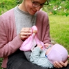 Une maman présente la poupée en soie rose à son petit bébé