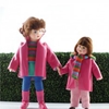 Erna Meyer poppenhuis poppetjes: kleine zus Nele en grote zus Louisa geven elkaar de hand, allebei in donker roze regenjas.
