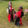 Twee kinderen spelen Noorman riddertje met helm, zwaard, schild en tabberd.